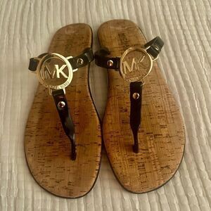 Michael Kors black patten, thong sandals with gold logo.